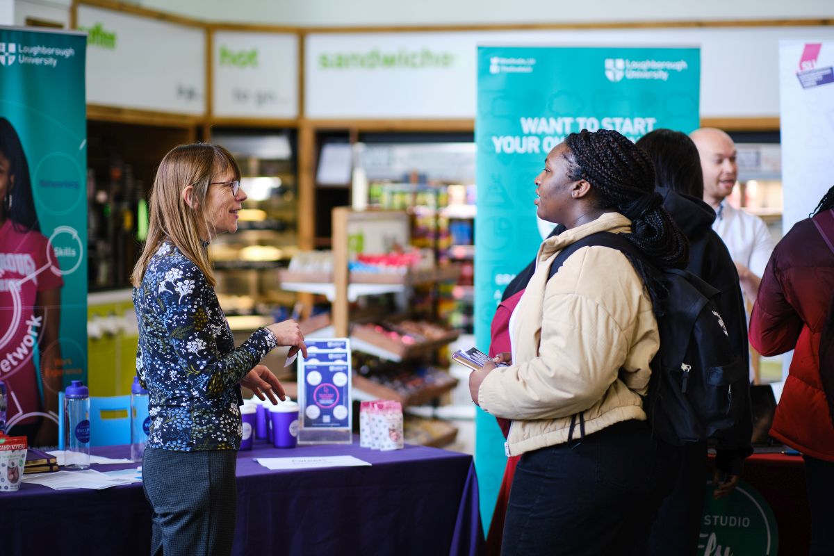 A student talking to a staff member at an exhibition